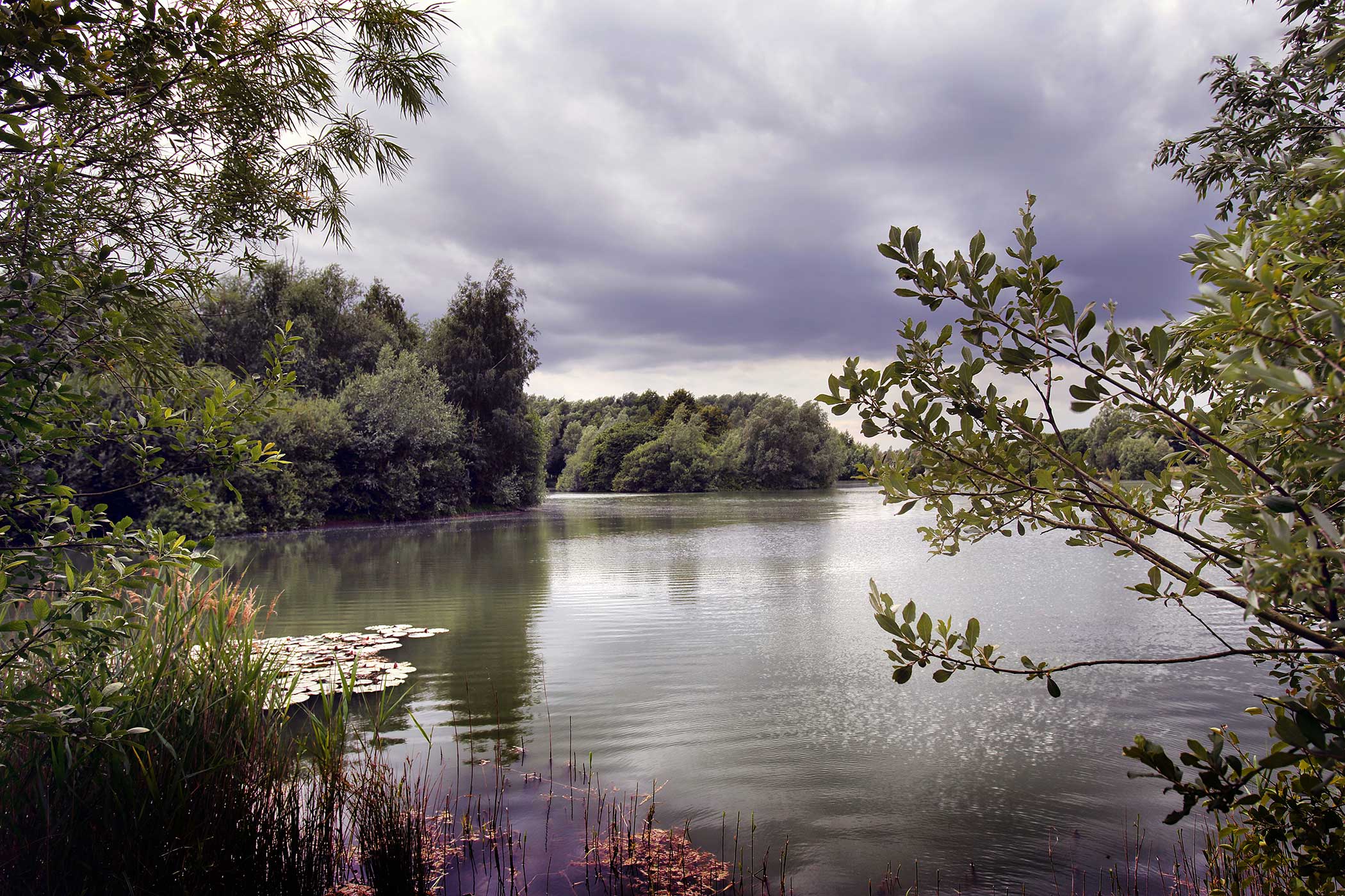 the lake at waterbeach barracks framed with trees