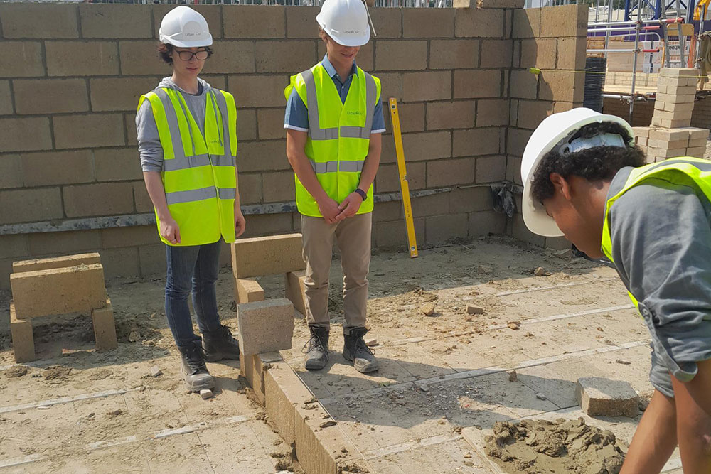 Two young people being taught on a construction site